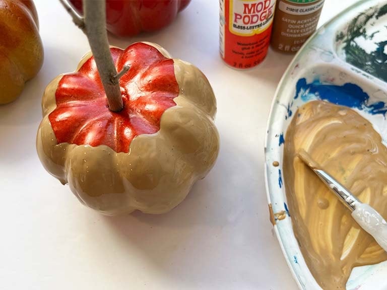 Caramel painted onto one faux caramel pumpkin apple.