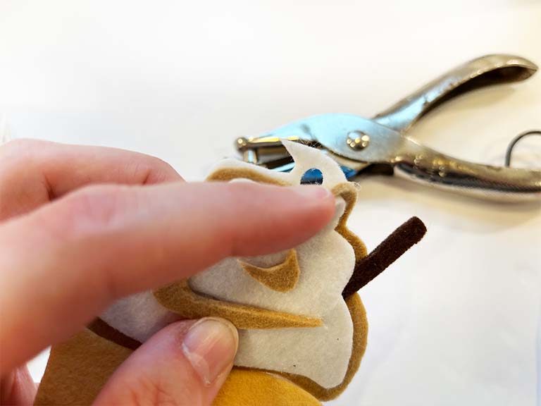 Make a hole using a hole punch at the top of a DIY Felt Air Freshener.