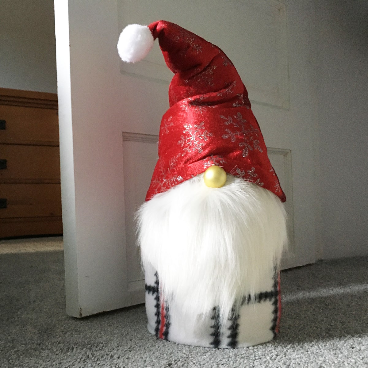 Square feature photo of a finished Santa Gnome used as a door stop.