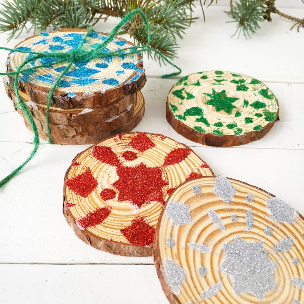 Photo of finished snowflake coasters in festive holiday colors with sprigs of pine in the background.
