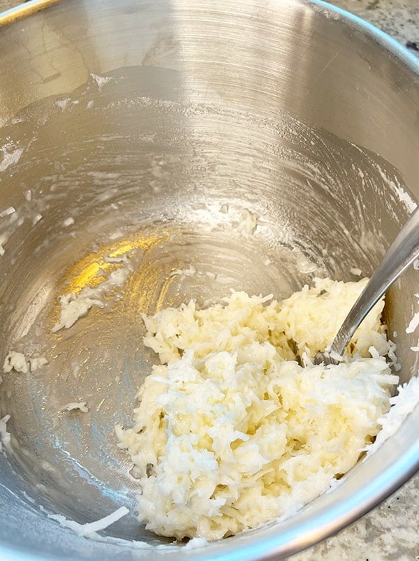 Process photo of a bowl of coconut filling that is thoroughly mixed and ready to be layered into the Bundt pan as the decadent coconut center of this moist and delicious chocolate Bundt cake.