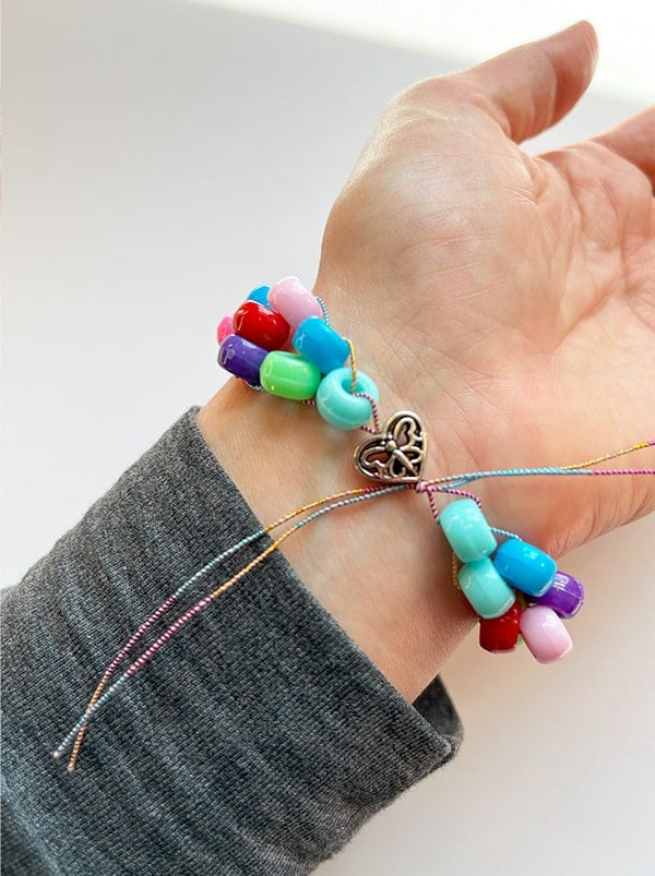 Photo showing the finished bracelet on a wrist that has been tied with two overhand knots. The ends of the cord have not been snipped away yet.