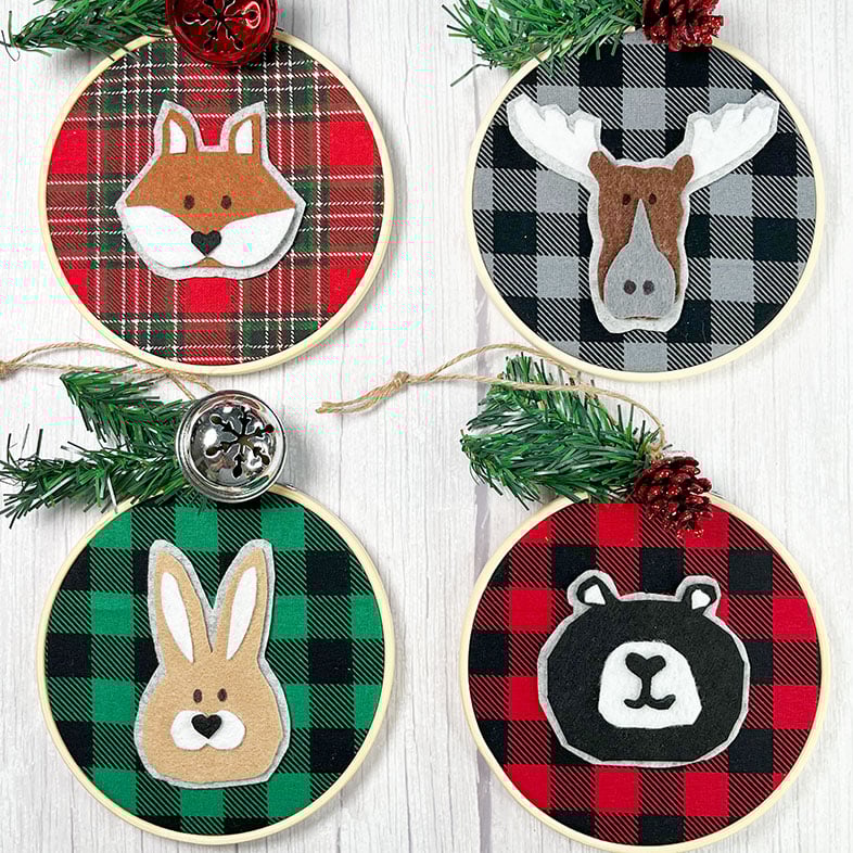 Square feature image of 4 woodland animal felt appliques placed on different plaid and buffalo check backgrounds in 5 inch embroidery hoops to make ornaments.
