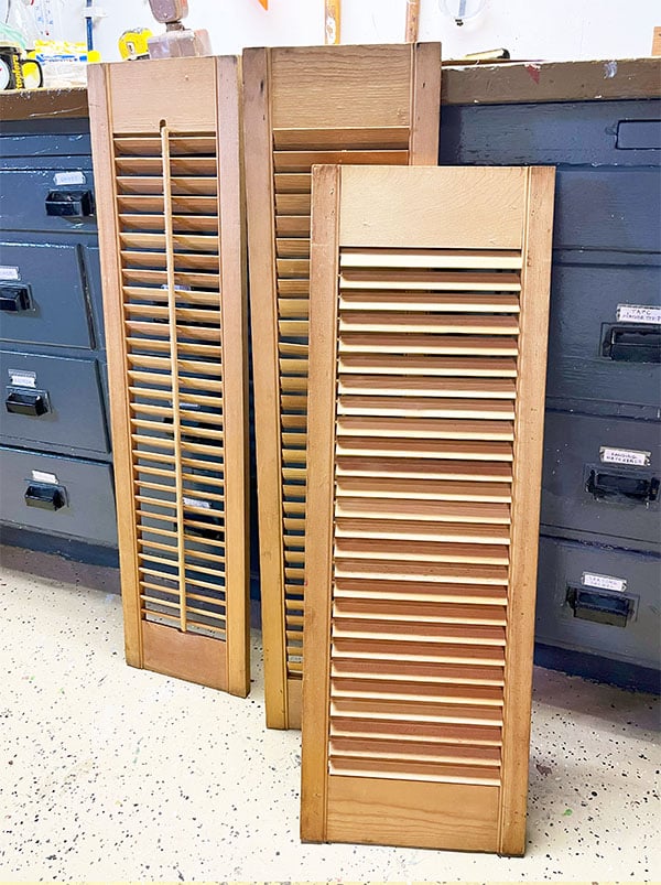 Three wood louvered shutters shown in a before picture. These will be used to make a card display rack.