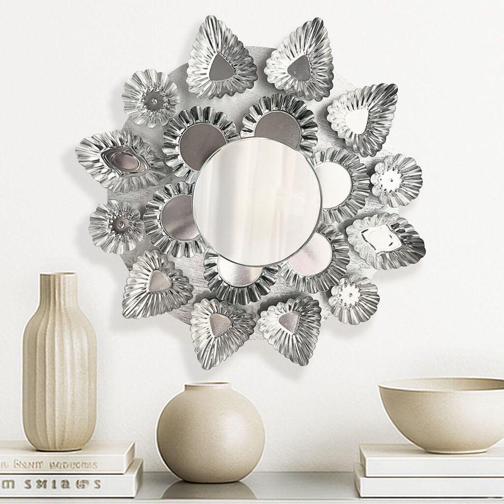 Mirror made of different shape tart tins in silver arranged in a round pattern on a silver round board with a small 5-inch accent mirror in the center over a table with vases and bowls in neutral tan.