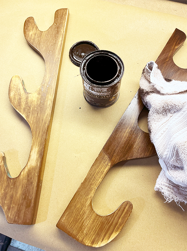 Staining the wood side pieces of an old gun rack to darken them to use as antlers on a DIY upcycled reindeer basket.