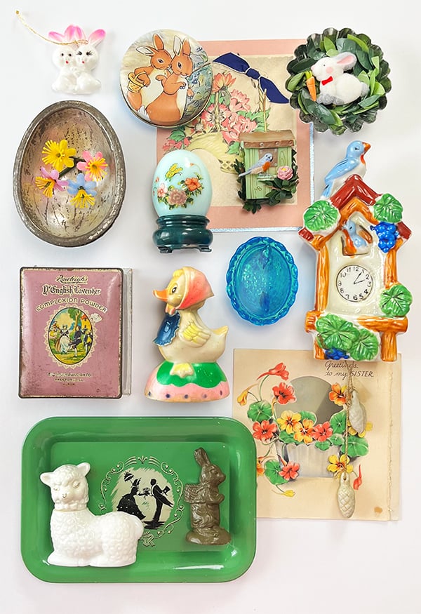 A visual study for the season. - Easter Collected and vintage object arrangement. These are all objects ranging from 2-4 inches in size with pastel colors to create a spring vingnette from blues to pinks, sea foam greens and tawny brown. There is a vintage Avon Bottle lamb in white, a pull back toy chick with bonnet, a handmade rabbit tart tin magnet from the studio, a chocolate metal egg mold and more.