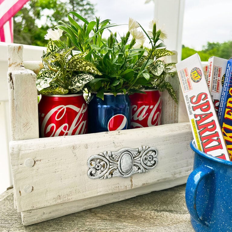 Old tiny caddy painted white fits three soda cans perfectly inside used a planters inside and a vintage enamel blue cup with boxes of sparklers.