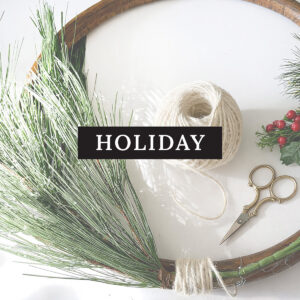 Square image button for Mobile under the Crafts menu Holiday DIY and crafts. Shown is the forming of a pine sprig wreath to a round wood found base with white twine ball, scissors, berry sprigs and greenery.