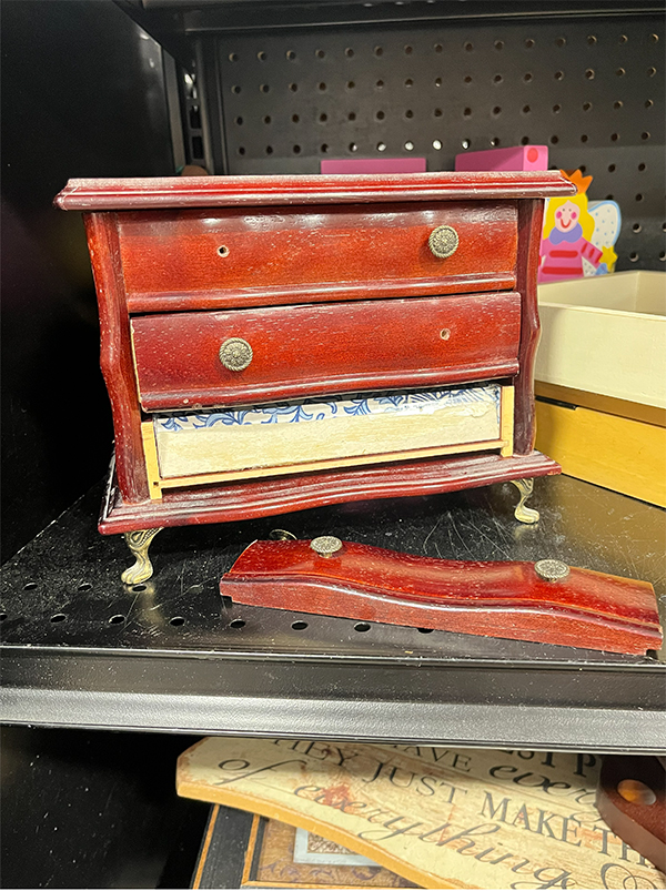 Broken cherry wood jewelry box with two drawers sitting on a thrift store shelf before its makeover.